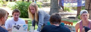 Students gather around a table outside of Patterson Hall to work on homework at SNU Tahoe