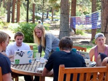 Students gather around a table outside of Patterson Hall to work on homework at SNC Tahoe