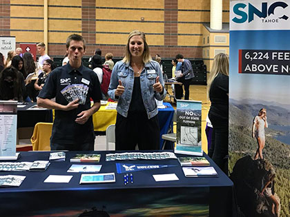 Sierra Nevada College admissions counselors man the booth at a high school college fair.