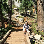 Psychology major Maggie Burns sits by bridge in Tahoe National Forest