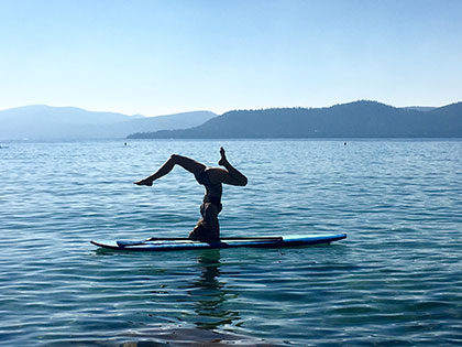 Student Kyly Clark practicing yoga on a paddleboard on Lake Tahoe