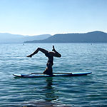 Kyly Clark, de Interdisciplinaire Studies, specialisatie Journalistiek en Digitale Kunsten en yoga-liefhebber, het doen van een brughouding op een paddleboard aan Lake Tahoe.