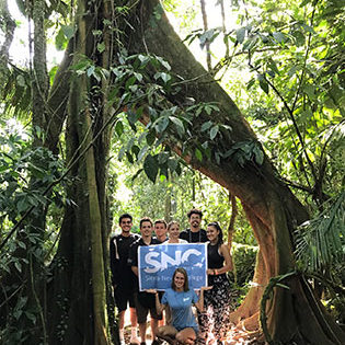 Sierra Nevada College students with the college flag at the La Selva Biological Station on a tropical ecology course in Costa Rica