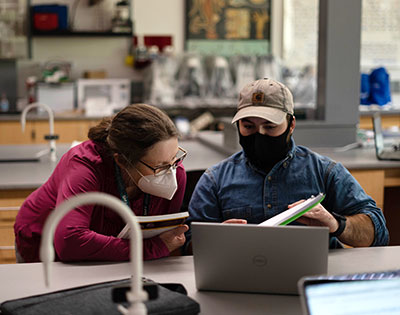 masked professor and student working in an SNU science lab