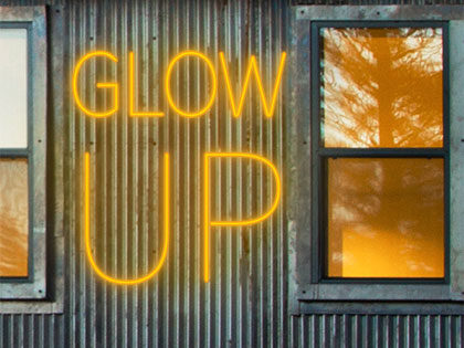 Glow Up fine arts alumni exhibition logo image of glowing amber neon on the Holman Arts and Media Center