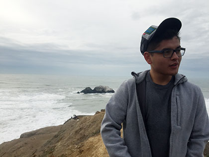 Angel Gonzalez, Psychology major, standing near the beach on a school trip