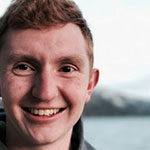 Creative Writing major Luke Hupp smiles with Lake Tahoe and Sierra Nevadas in the background