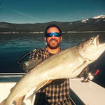 Andrew Lubrano, Finance and Economics major, poses with big catch on his boat on Lake Tahoe