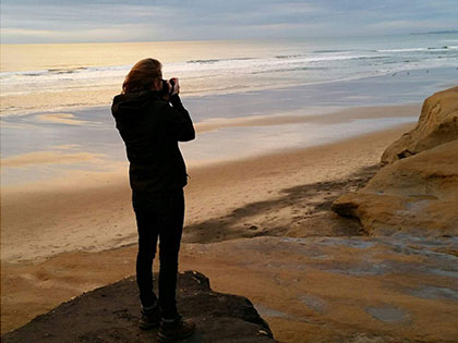 Journalism and digital arts student Morgan Meadows photographing sunset on the beach