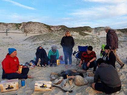Students building a bonfire on the beach in Monterey during a Sierra Nevada College science trip.