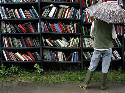 Women browsing books in the rain in Hay-on-Wye, Wales famous as the "Town of Books"