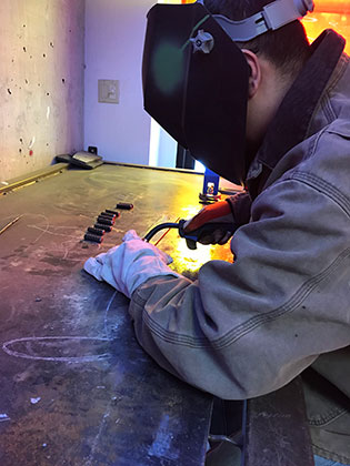SNC fine arts student Adrian Pinal-Gonzalez welding his sculpture