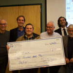 Zach Krahnke poses with his big check after winning third place in the annual pitch competition at SNC Tahoe.