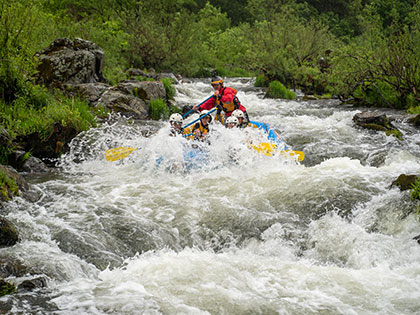 A student guides a paddle boat down a Class III rapid - Sierra Nevada College environmental science and outdoor adventure leadership students in field courses on the Wild and Scenic Rogue River