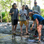 students learning how to measure water flow in a tributary stream - Sierra Nevada University environmental science and outdoor adventure leadership students in field courses on the Wild and Scenic Rogue River