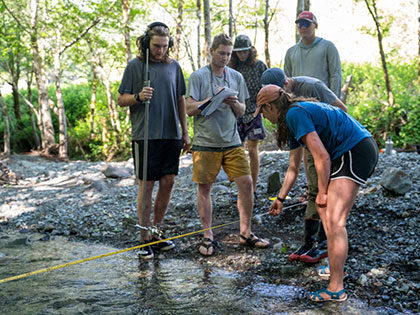 students learning how to measure water flow in a tributary stream - Sierra Nevada University environmental science and outdoor adventure leadership students in field courses on the Wild and Scenic Rogue River