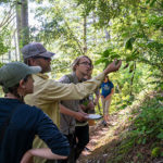 students identifying tree species along the trail on a hike - Sierra Nevada University environmental science and outdoor adventure leadership students in field courses on the Wild and Scenic Rogue River
