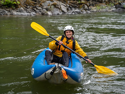 a student paddles a solo inflatable kayak - Sierra Nevada College environmental science and outdoor adventure leadership students in field courses on the Wild and Scenic Rogue River