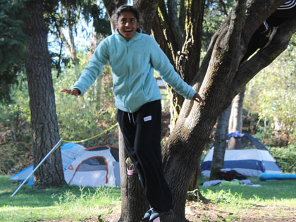 student enjoying the slack line at the campsite in Coloma CA at the Sierra Nevada University orientation river camp adventure