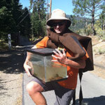 Gus Tjenagel, Science major, holding tank with non-native fish to put in Truckee River