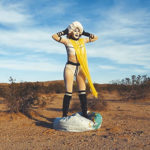 Still image of a woman in the desert dressed as a clown superhero from the film Rituals of a Globalist by Julie Weitz, an experimental LA-based artist working in video, performance, and installation.