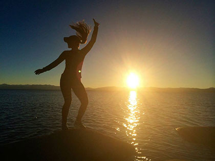 Global Business Management major Kristine Adde dances at sunset shoreside at Lake Tahoe