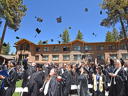 Sierra Nevada College graduates through their hats in the air at the end of the commencement ceremony.