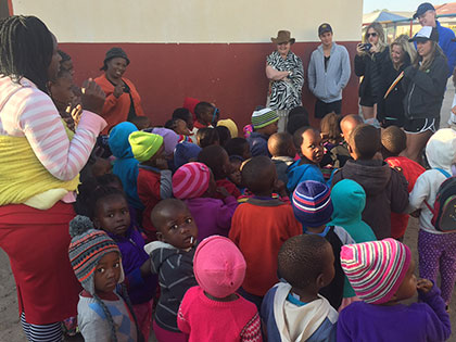 Students at a rural preschool in South Africa gather around so they can see the improvements made to their schoolhouse by Sierra Nevada College International Studies Students