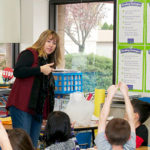 teacher in front of an enthusiastic elementary classroom