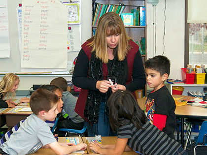 Female teacher engaged with her students in an elementary school classroom